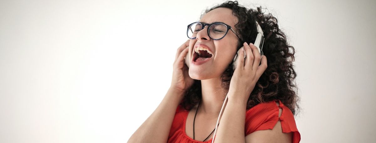 Frau singt laut mit Kopfhörern