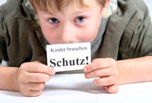 Kind hält Schild in der Hand