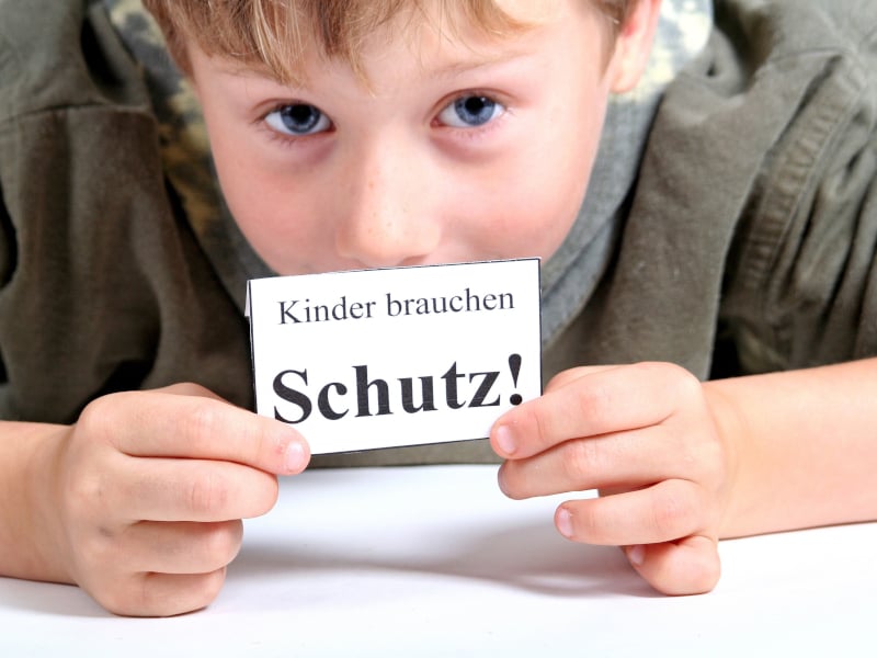 Kind hält Schild in der Hand